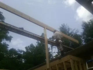 Carpenter setting a ridge beam over a new addition frame — Ice Dam Removal by Roofing Brothers in Egan