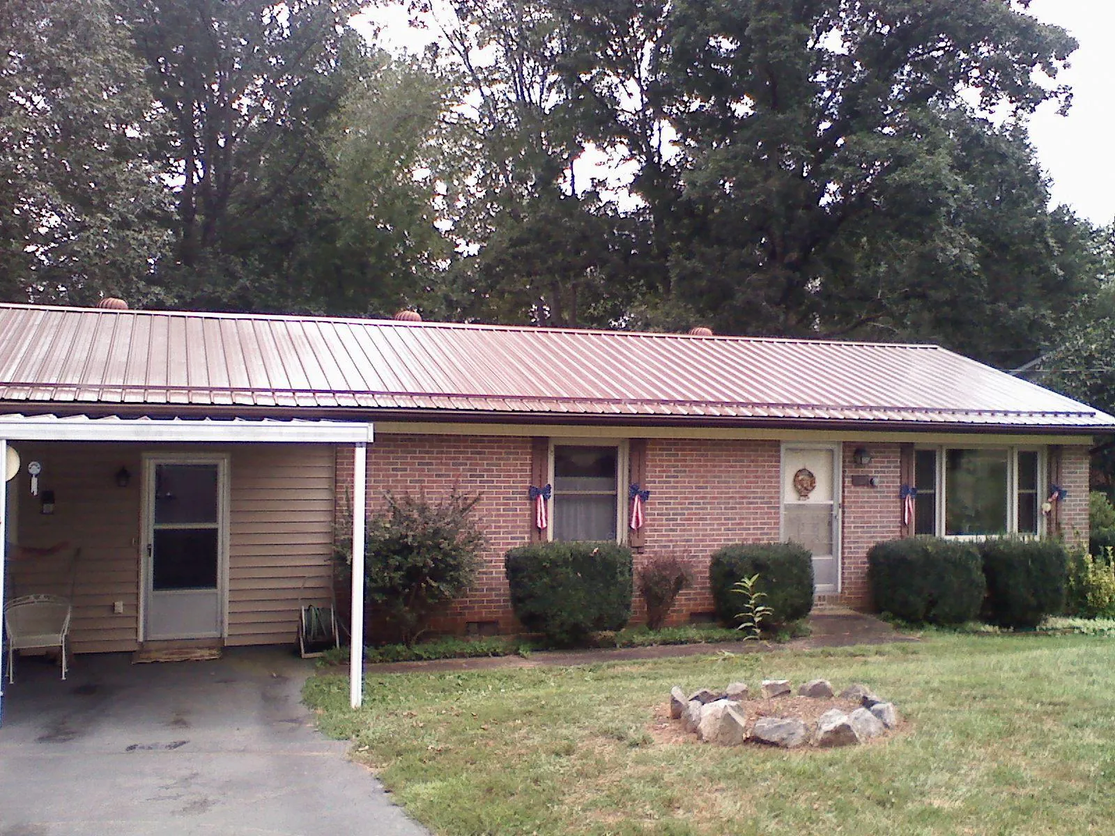 Bronze metal roof and carport on a brick ranch home — Roof Repair work by our crew in Egan